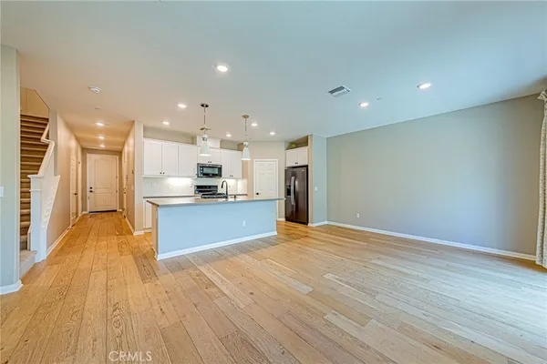 a view of kitchen with kitchen island and stainless steel appliances