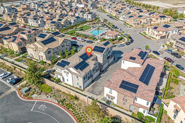 an aerial view of residential houses with outdoor space and parking