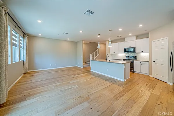 a view of kitchen with kitchen island wooden floor and center island