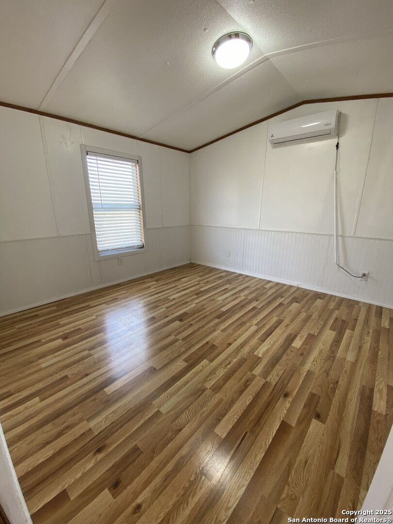 113 Lake Mertzon, TX 76941 - Photo 12 of 14 an empty room with wooden floor and windows