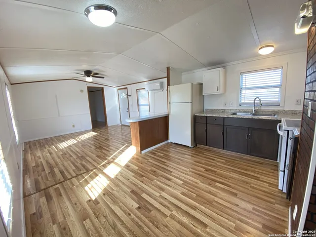 a view of kitchen with sink and refrigerator
