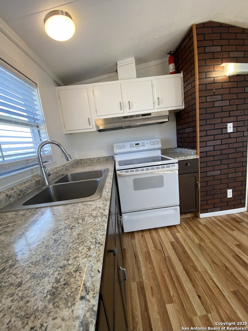 113 Lake Mertzon, TX 76941 - Photo 4 of 14 a kitchen with a stove sink and cabinets