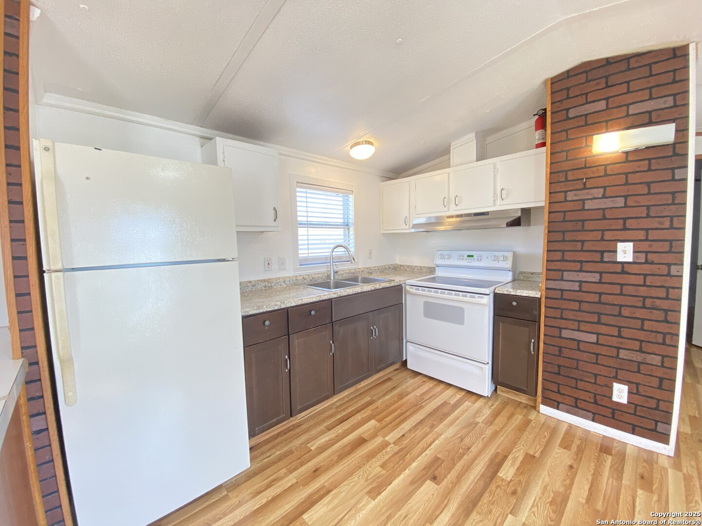 113 Lake Mertzon, TX 76941 - Photo 6 of 14 a kitchen with a sink a refrigerator a window and cabinets