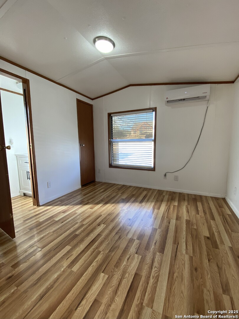 113 Lake Mertzon, TX 76941 - Photo 10 of 14 an empty room with wooden floor and windows