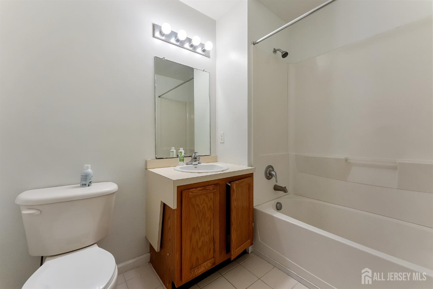 128 Remsen Avenue, Unit A New Brunswick, NJ 08901 - Photo 13 of 18 a bathroom with a toilet sink and mirror