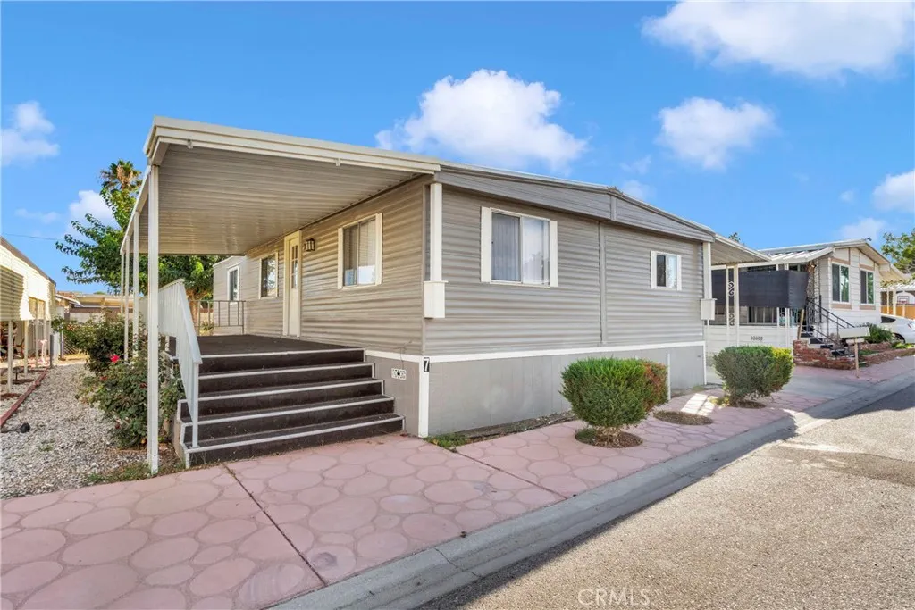 15252 Seneca Road, Unit 7 Victorville, CA 92392 - Photo 1 of 1 a front view of a house with a yard and potted plants