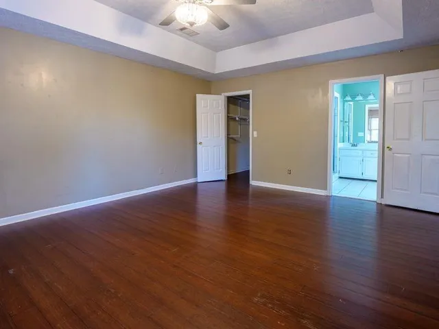 a view of an empty room with wooden floor