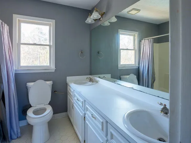 a spacious bathroom with a toilet sink and mirror