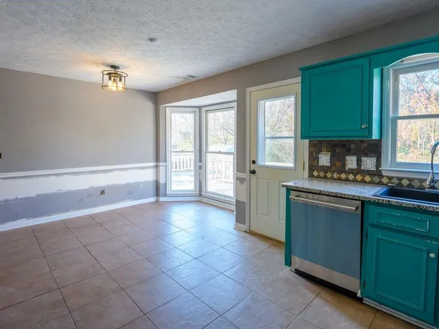 a kitchen with granite countertop a stove a sink and a refrigerator