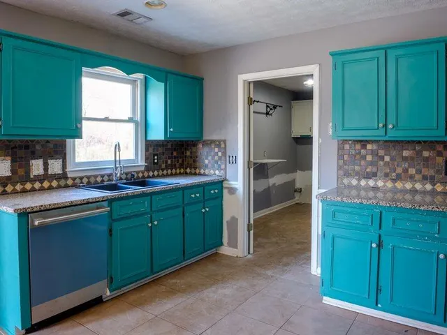 a kitchen with cabinets a sink and a window