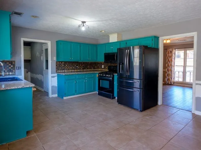 a kitchen with stainless steel appliances granite countertop a refrigerator and a sink