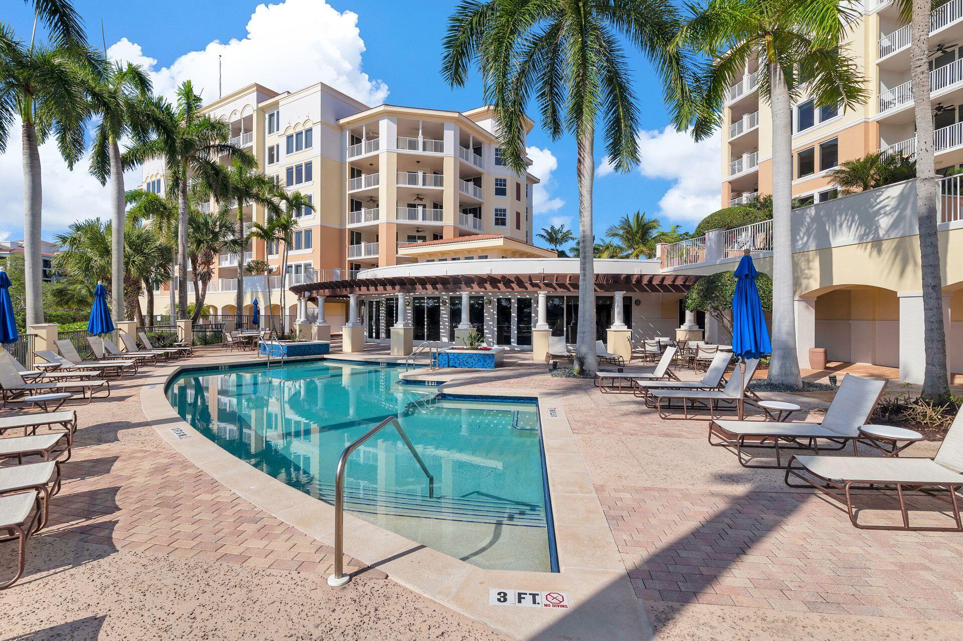 700 Highway 1, Unit 401 Jupiter, FL 33477 - Photo 37 of 39 a view of a swimming pool with chairs and palm tree