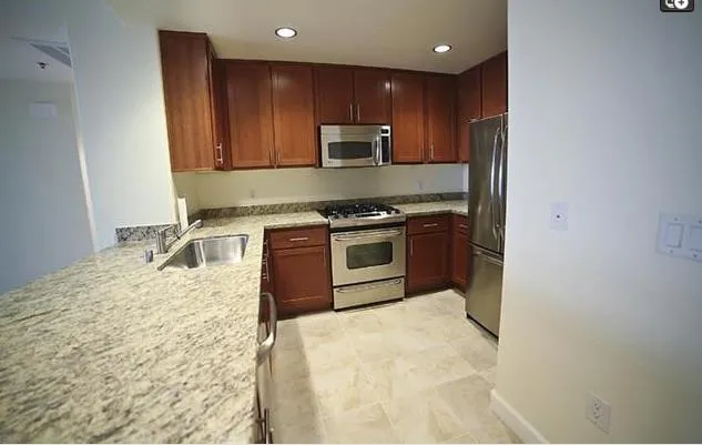a kitchen with stainless steel appliances granite countertop a stove a sink and a microwave