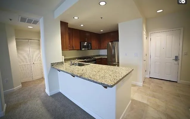 a kitchen with stainless steel appliances granite countertop a sink and a refrigerator