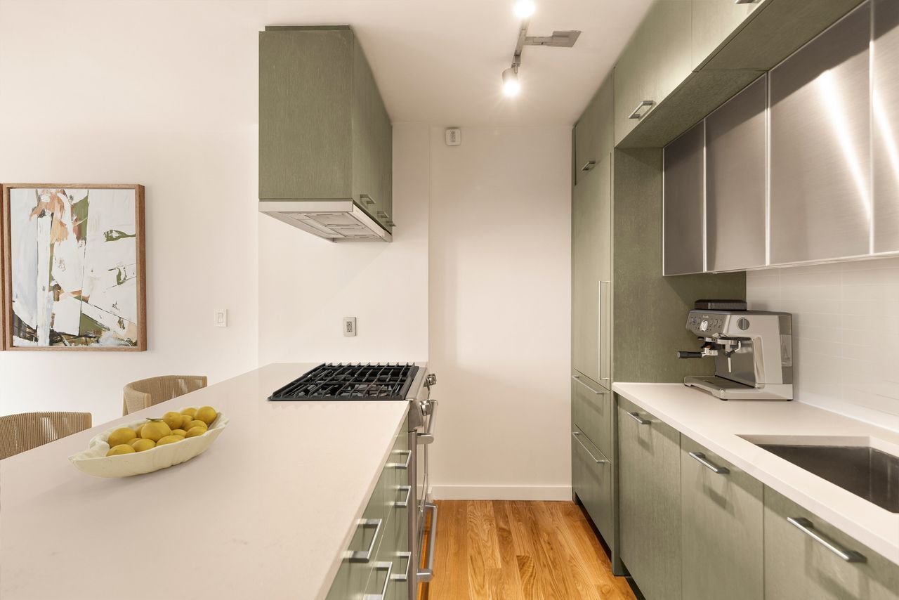 225 Rector Place, Unit 22J Manhattan, NY 10280 - Photo 5 of 8 a kitchen that has a sink and a stove in it