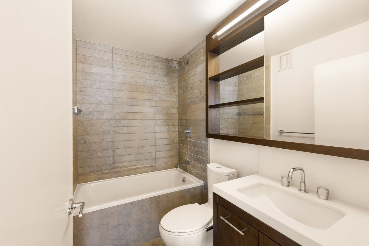 225 Rector Place, Unit 22J Manhattan, NY 10280 - Photo 6 of 8 a bathroom with a sink toilet and shower