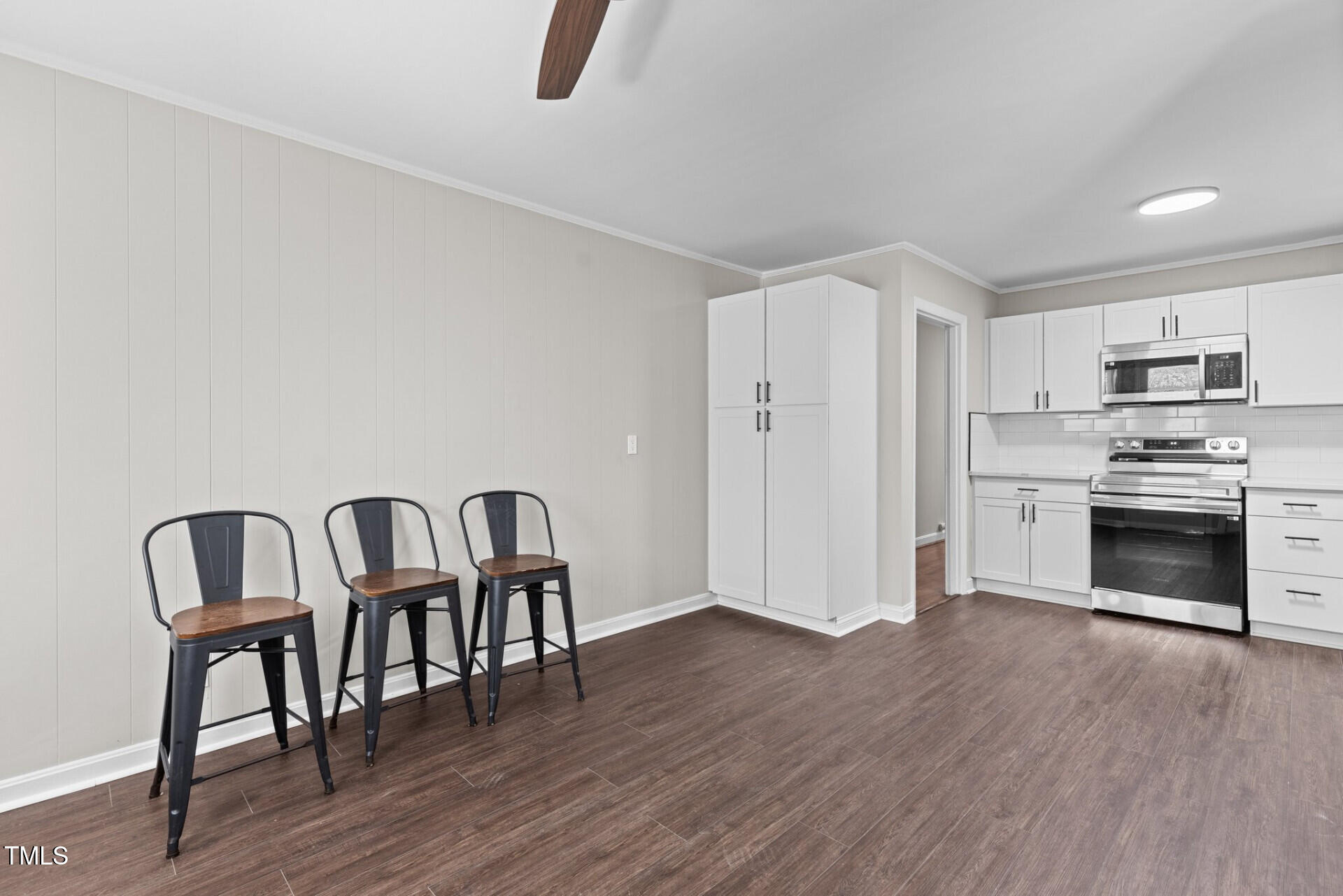 4828 Stafford Drive Durham, NC 27705 - Photo 6 of 22 a kitchen with granite countertop a dining table chairs and a refrigerator