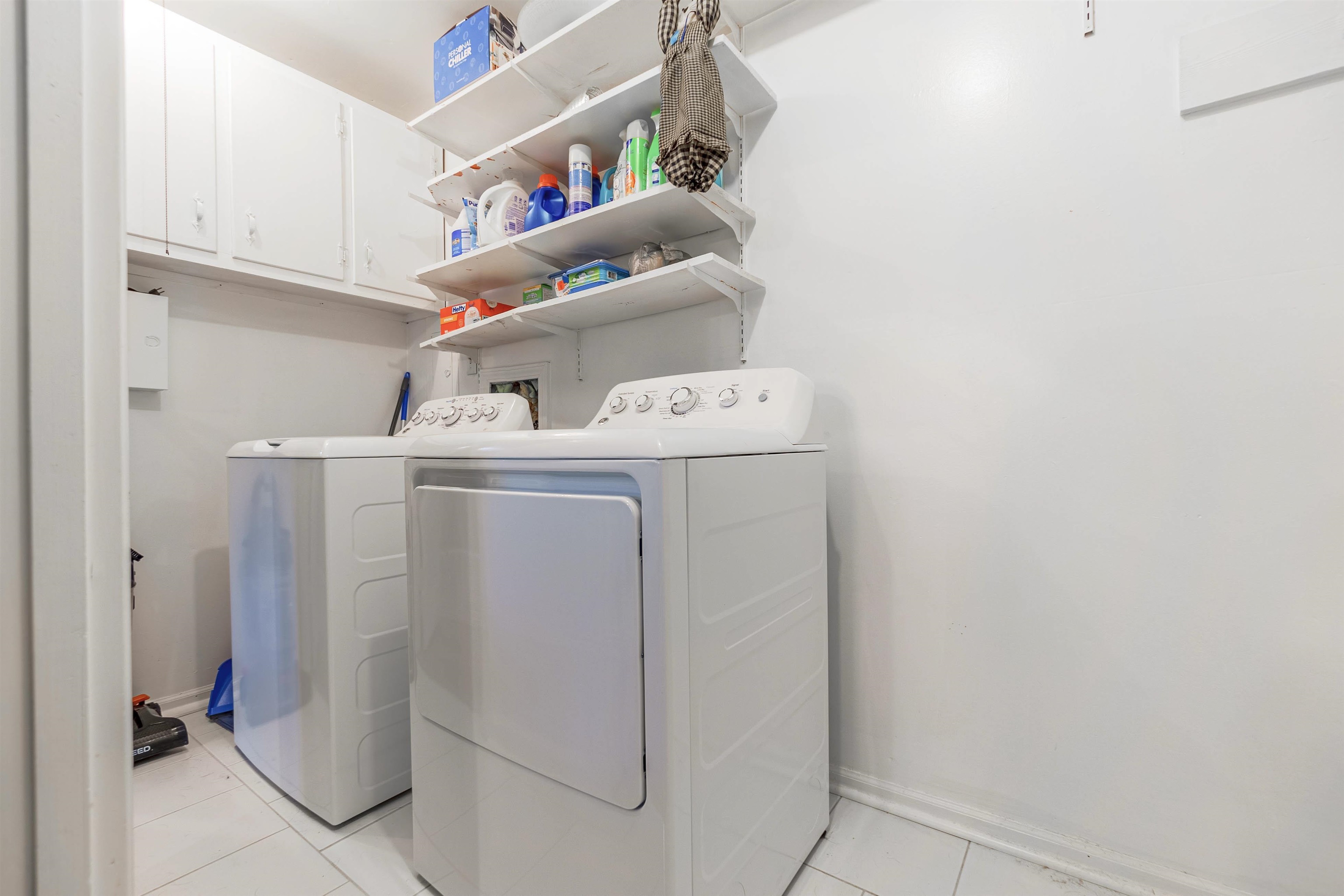 436 Clower Road Memphis, TN 38109 - Photo 12 of 22 Laundry room with cabinets, washer and dryer, and light tile patterned floors