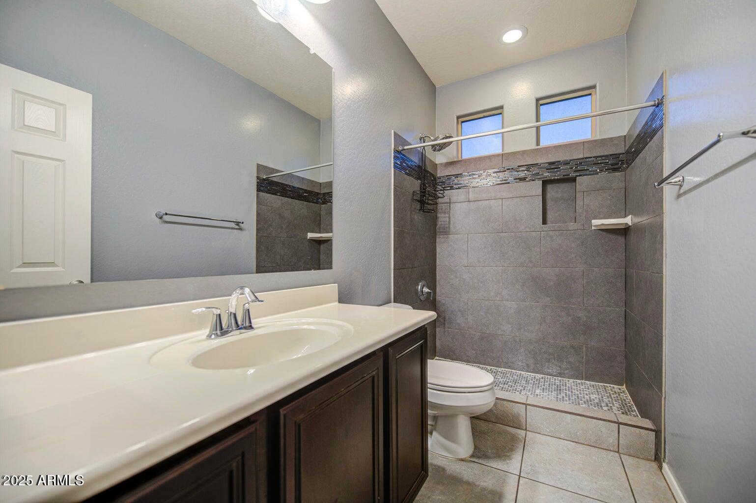 6815 South 19th Lane Phoenix, AZ 85041 - Photo 24 of 40 a bathroom with a sink a toilet and shower