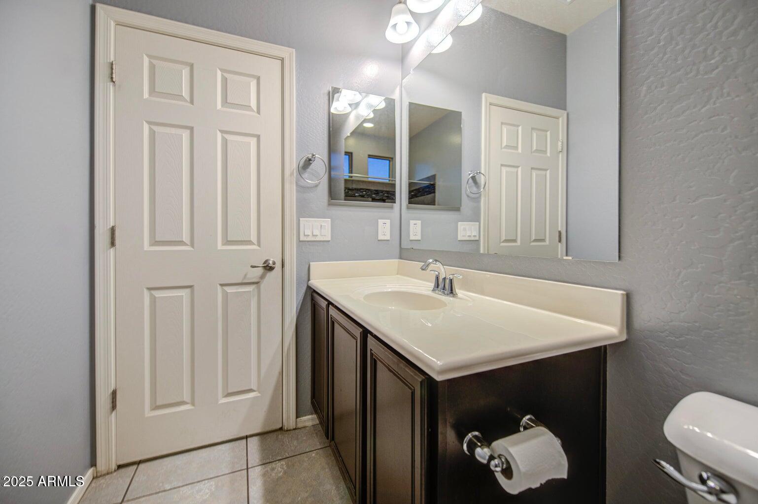 6815 South 19th Lane Phoenix, AZ 85041 - Photo 25 of 40 a bathroom with a sink vanity and a mirror