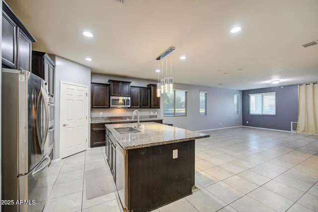 a kitchen with stainless steel appliances granite countertop a sink stove and refrigerator