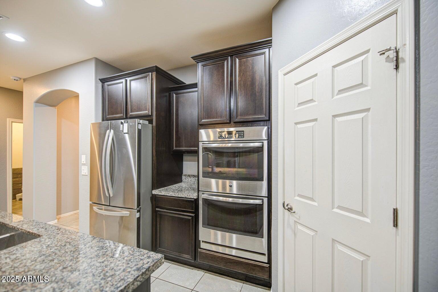 6815 South 19th Lane Phoenix, AZ 85041 - Photo 6 of 40 a kitchen with stainless steel appliances granite countertop a refrigerator and a sink