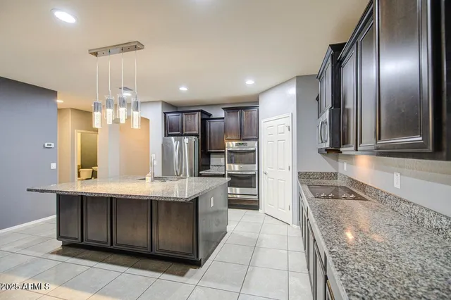 a kitchen with stainless steel appliances granite countertop a refrigerator a sink and a stove