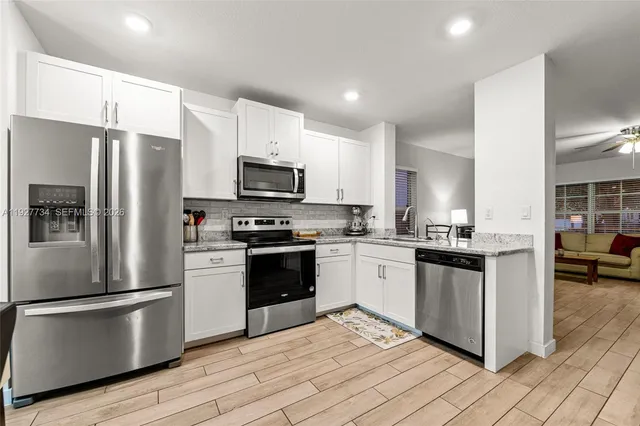 a kitchen with granite countertop a refrigerator stove and kitchen island