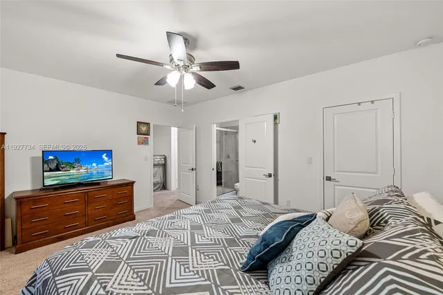 a spacious bedroom with a bed window and a flat screen tv