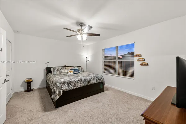 a spacious bedroom with a bed window and a flat screen tv