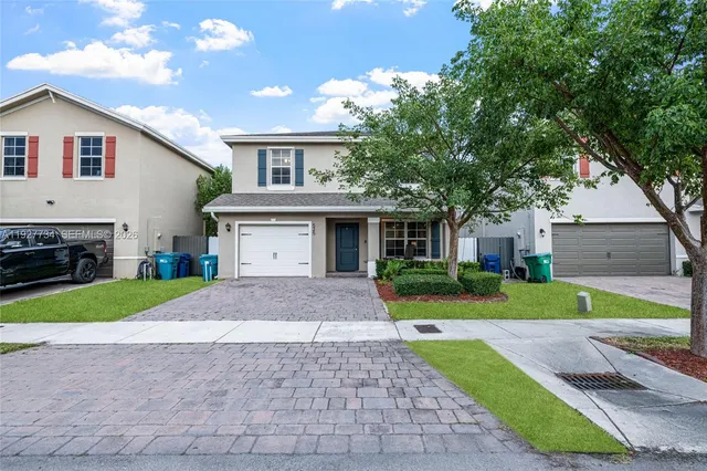 a front view of a house with a yard and garage