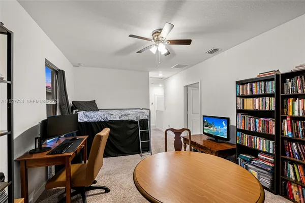 a work room with furniture bookshelf and a window