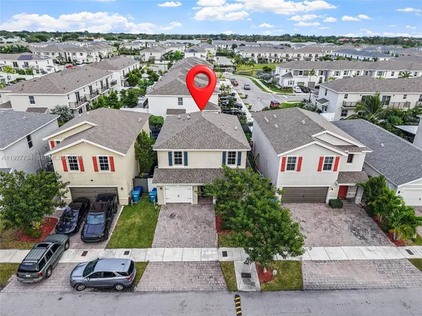 an aerial view of residential houses with outdoor space and parking