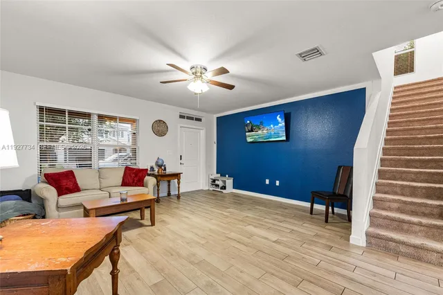 a living room with furniture and wooden floor
