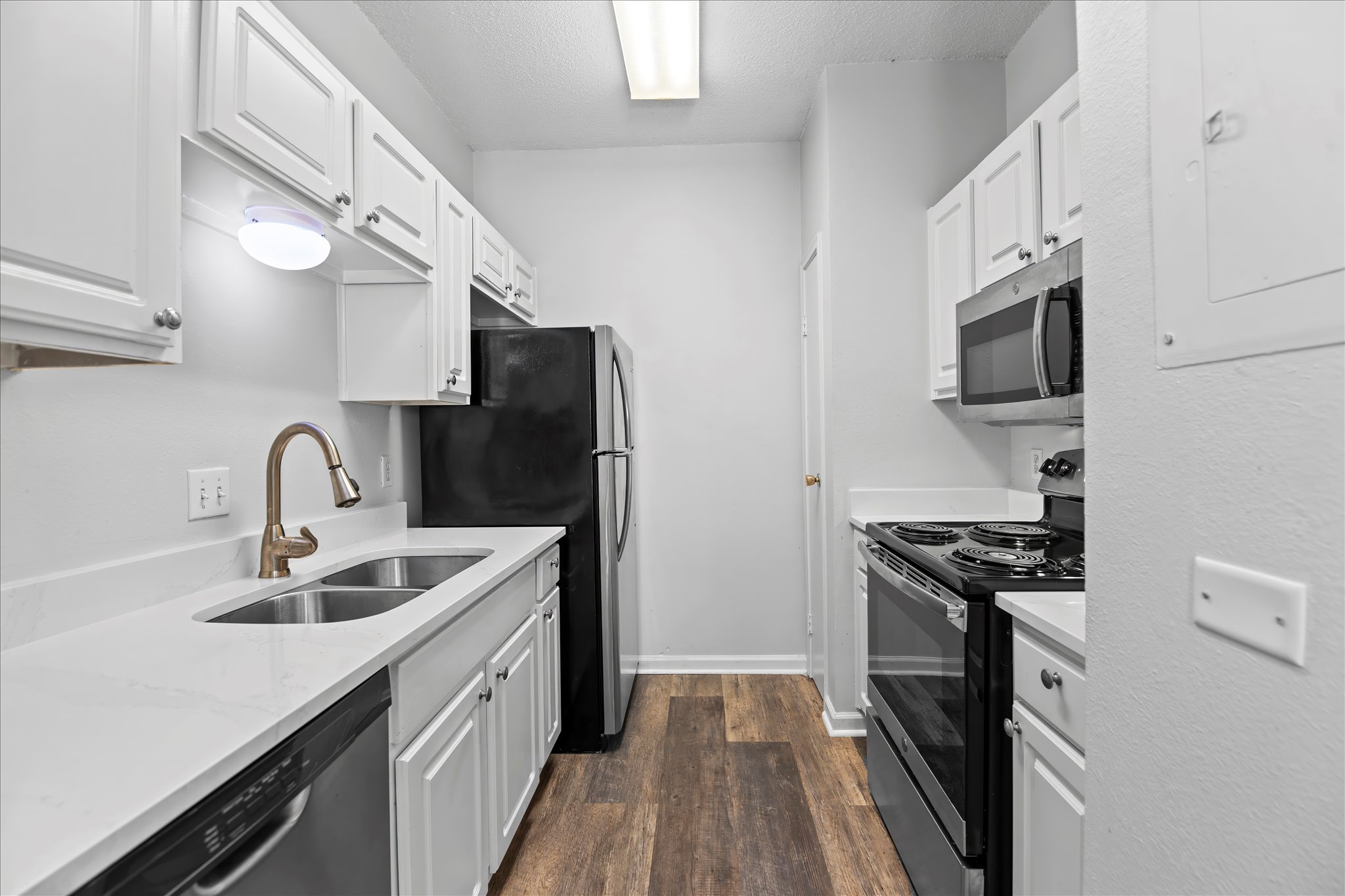 12166 Metric Boulevard, Unit 233 Austin, TX 78758 - Photo 4 of 13 a kitchen with stainless steel appliances granite countertop a sink stove and refrigerator