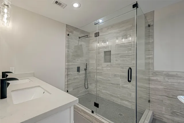 a view of an empty room with wooden floor and a ceiling fan