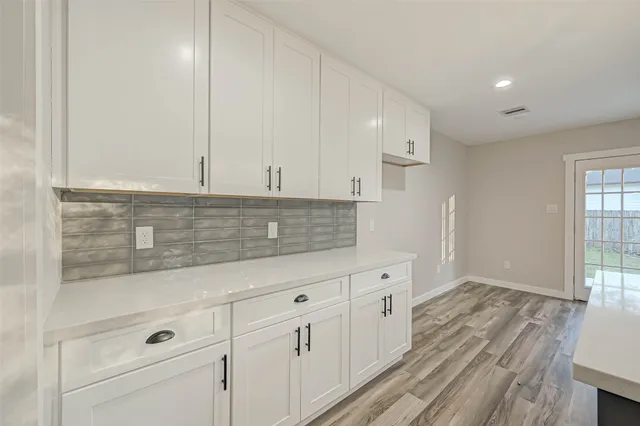 a view of granite countertop white cabinets and window