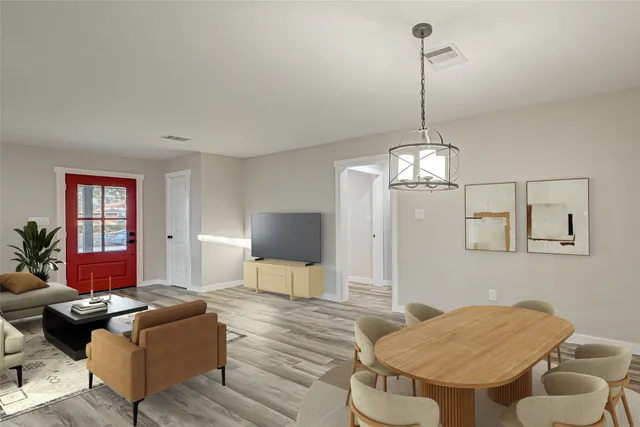 a living room with furniture a dining table and a chandelier