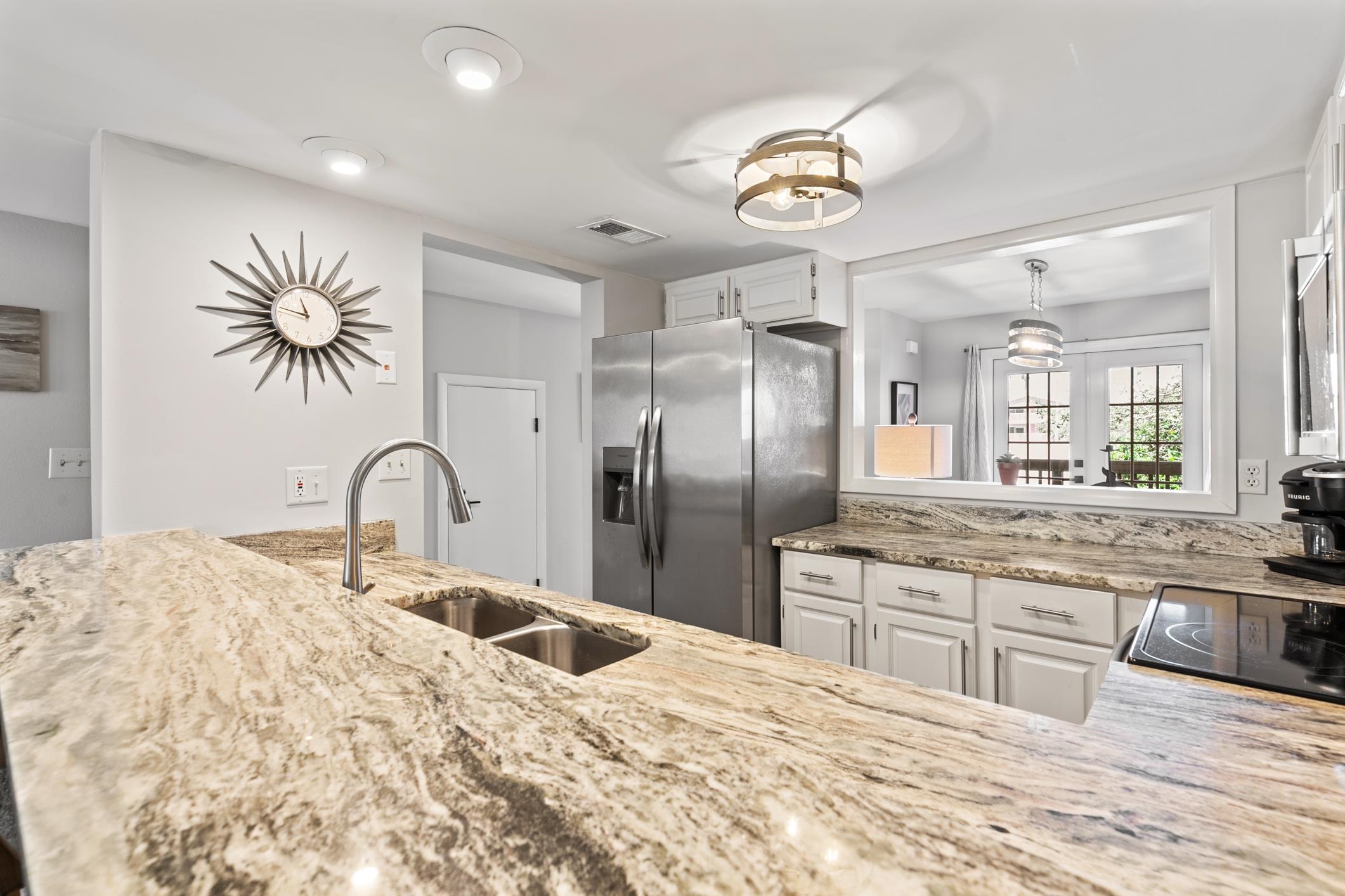 a large kitchen with stainless steel appliances kitchen island granite countertop a granite counter tops and a view of living room
