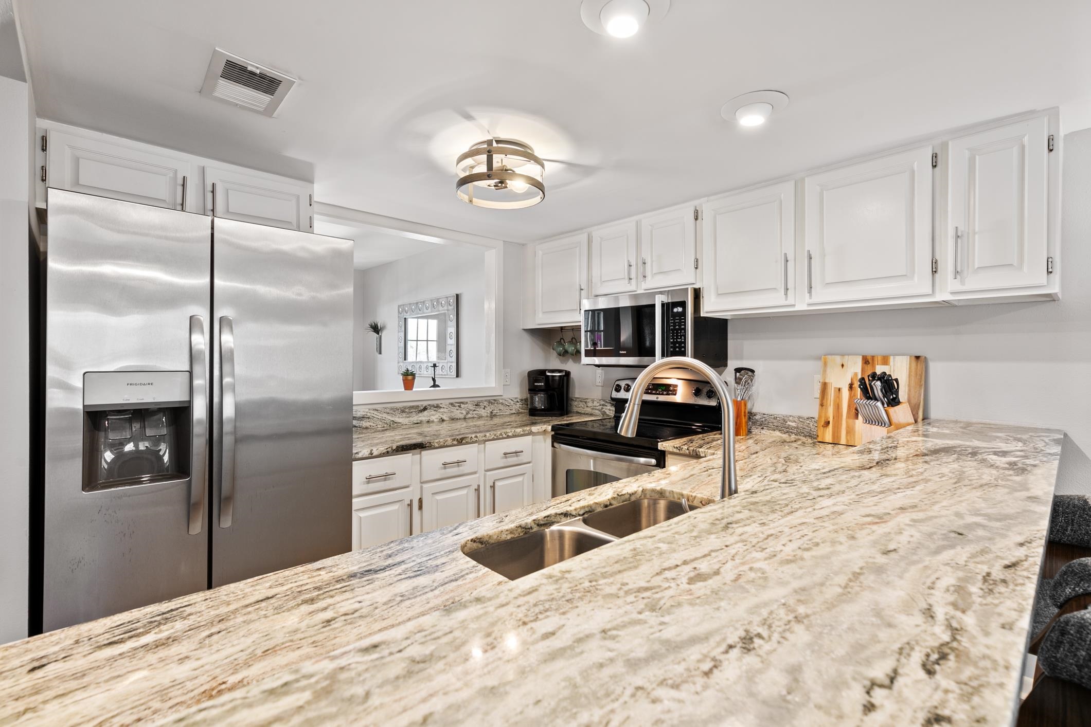 200 16th Street, Unit 202A St. Augustine, FL 32080 - Photo 11 of 39 a kitchen with granite countertop a refrigerator and microwave