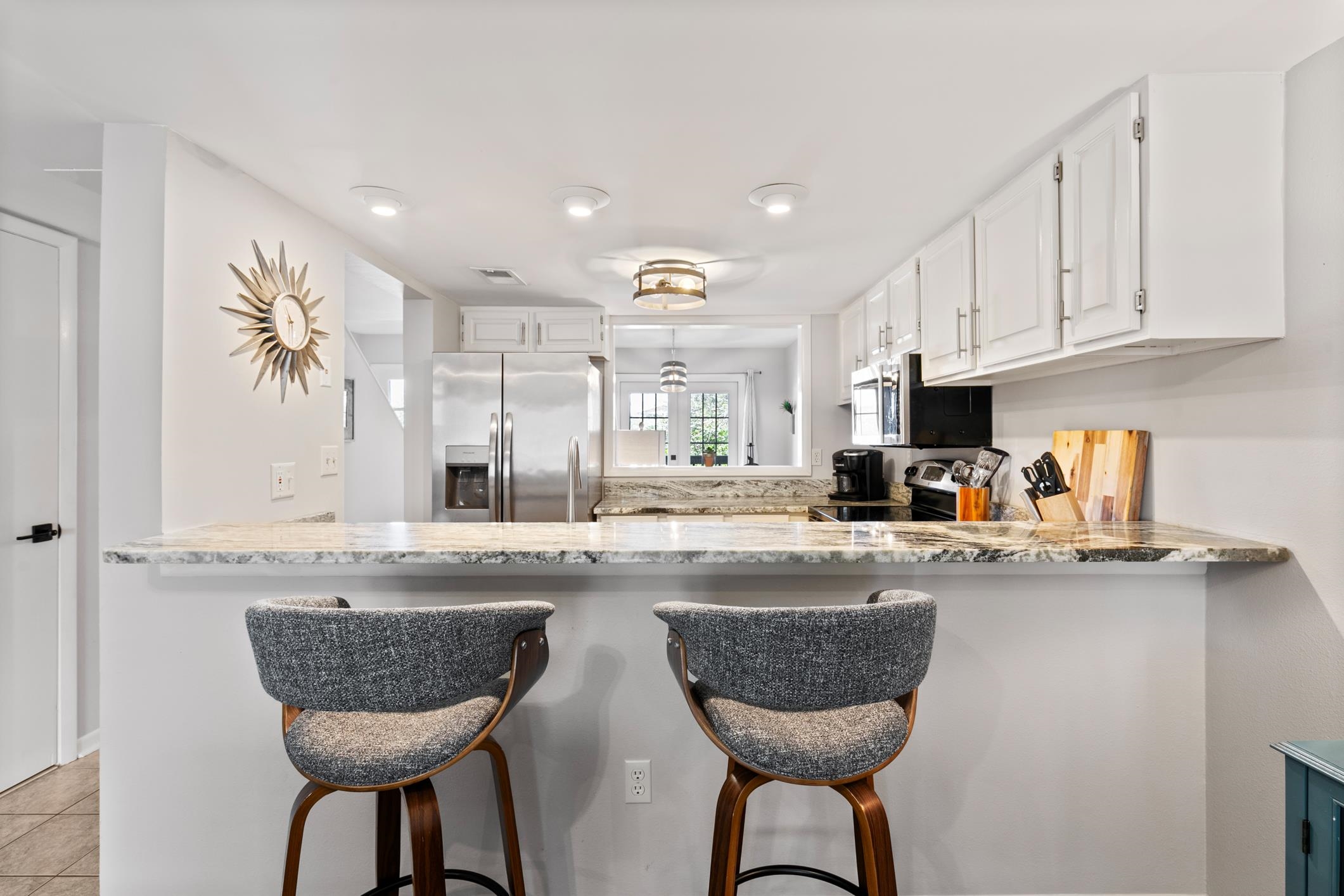 200 16th Street, Unit 202A St. Augustine, FL 32080 - Photo 12 of 39 a kitchen with granite countertop a counter space chairs cabinets and appliances