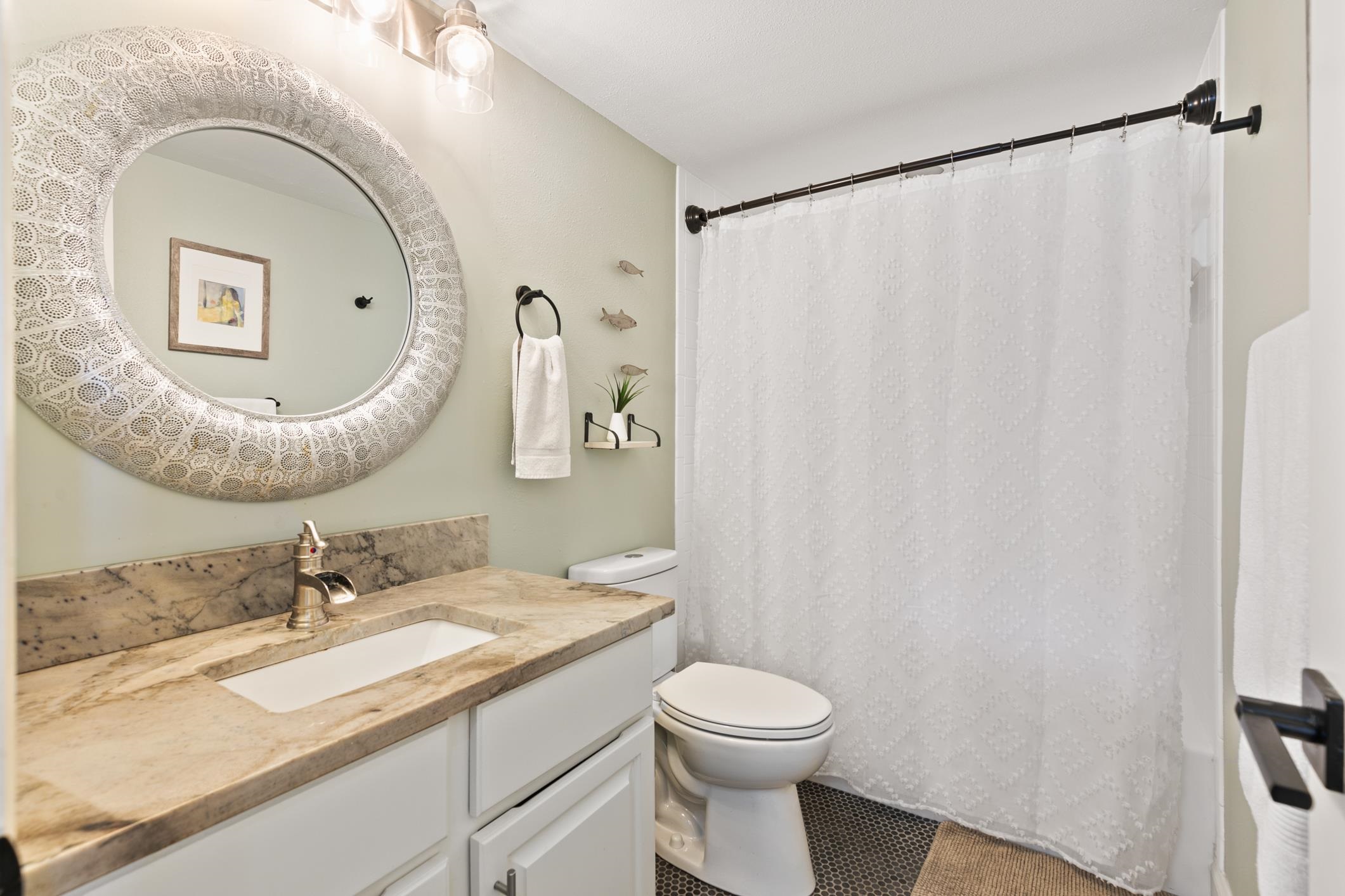 200 16th Street, Unit 202A St. Augustine, FL 32080 - Photo 29 of 39 a bathroom with a granite countertop sink mirror vanity and toilet