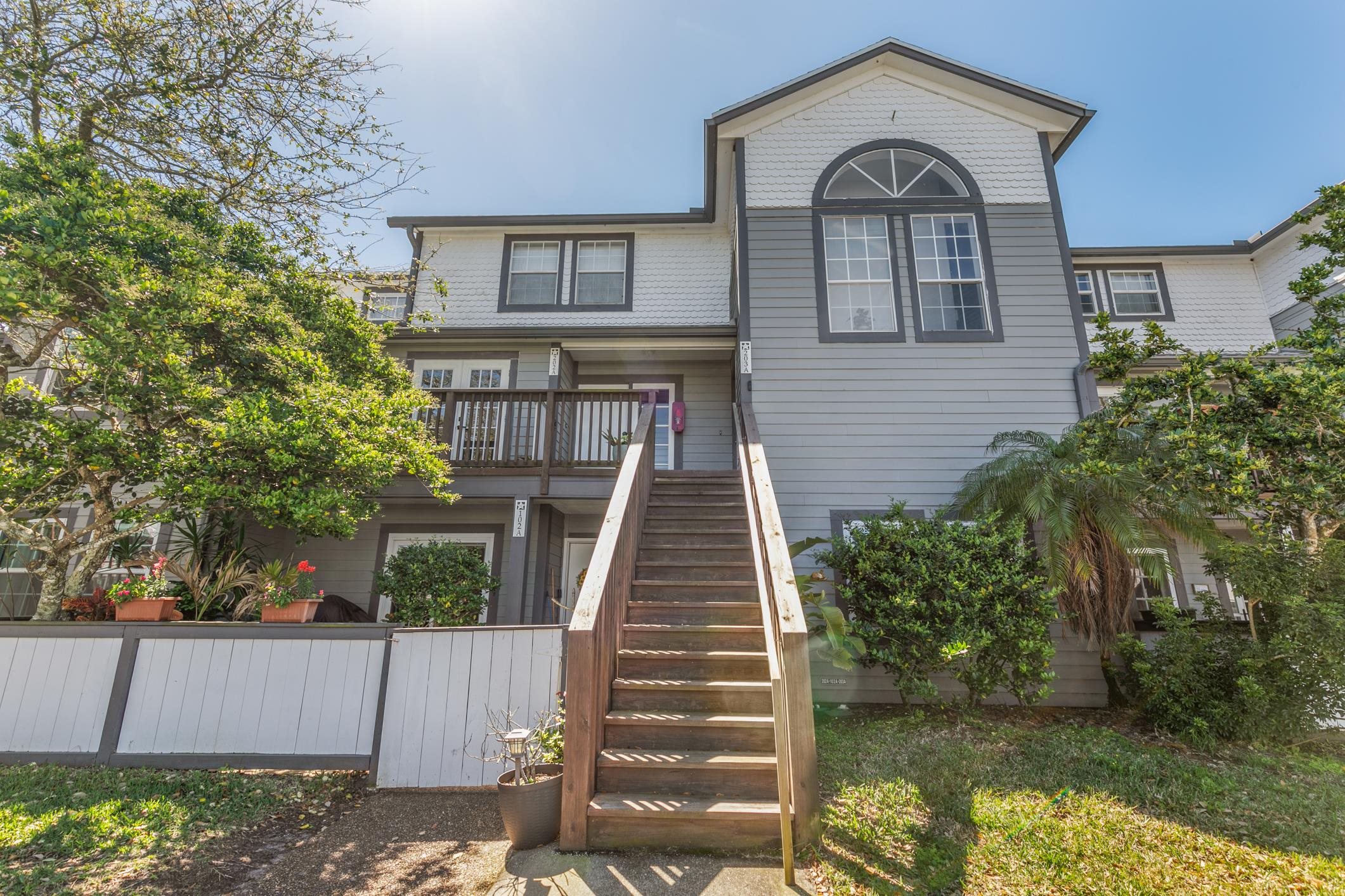 200 16th Street, Unit 202A St. Augustine, FL 32080 - Photo 3 of 39 a view of a brick house with large windows and a small yard