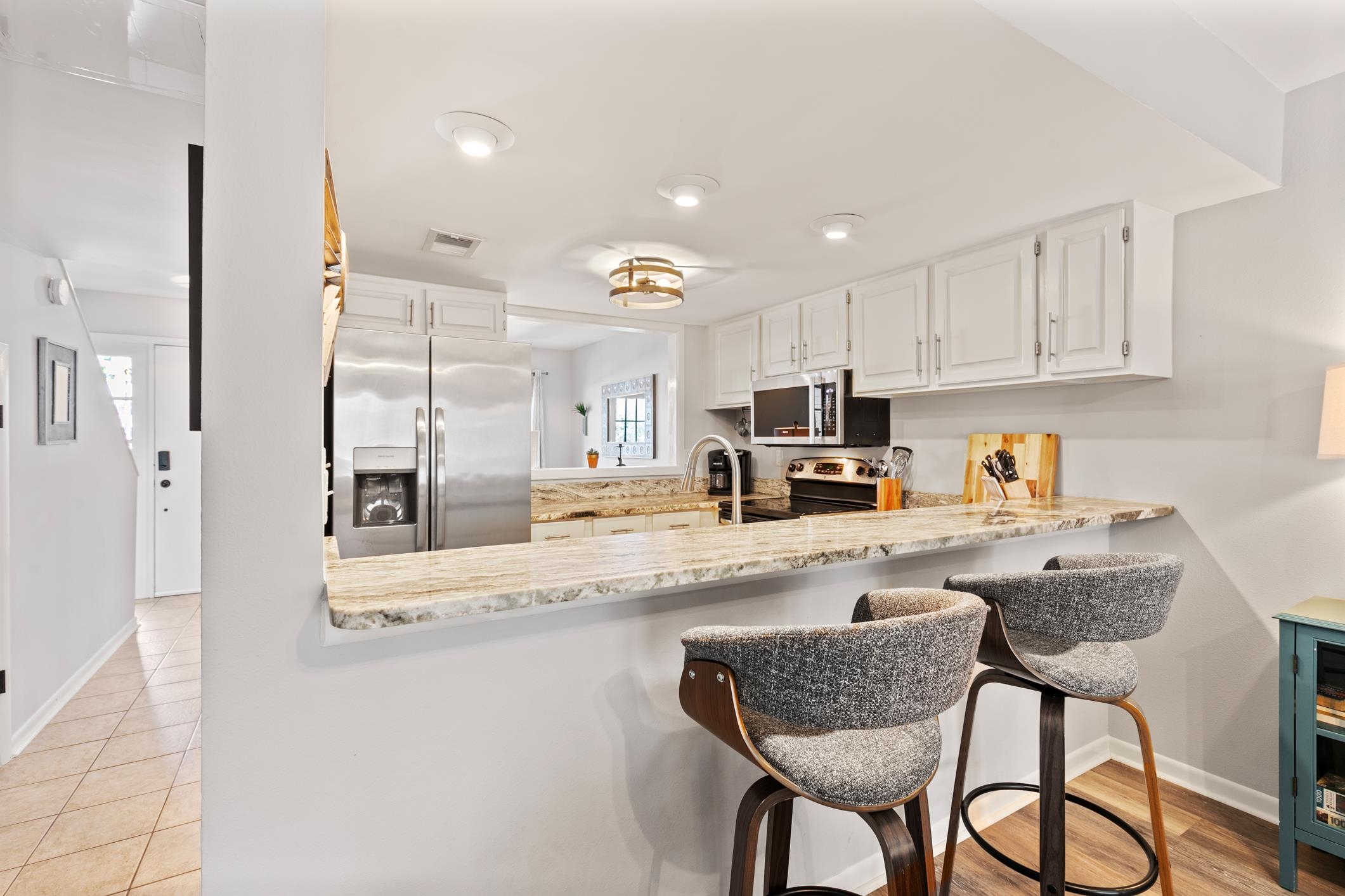200 16th Street, Unit 202A St. Augustine, FL 32080 - Photo 10 of 39 a kitchen with granite countertop cabinets and chairs