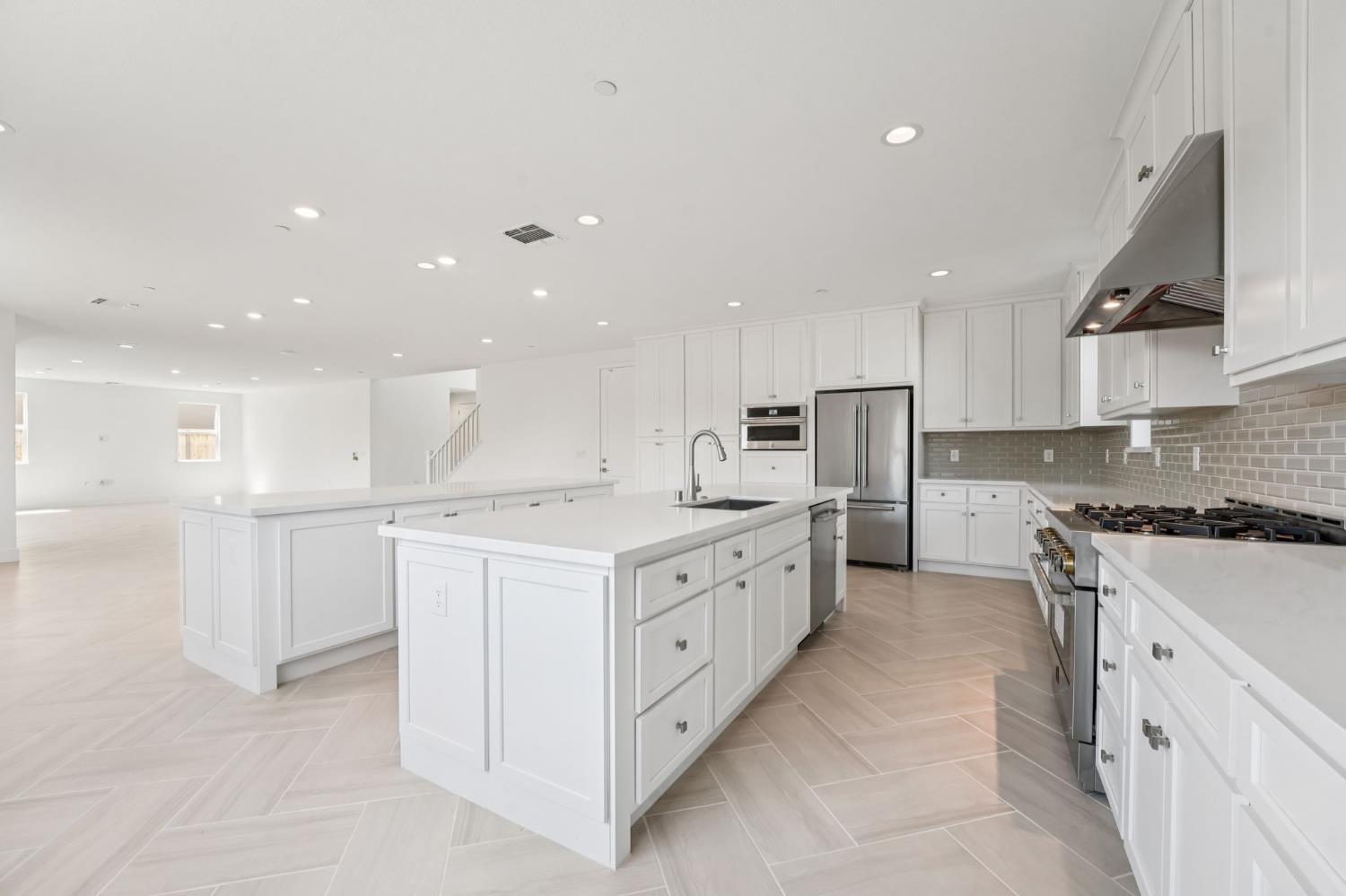 464 Trellis Way Brentwood, CA 94513 - Photo 3 of 22 a large kitchen with stainless steel appliances and white cabinets
