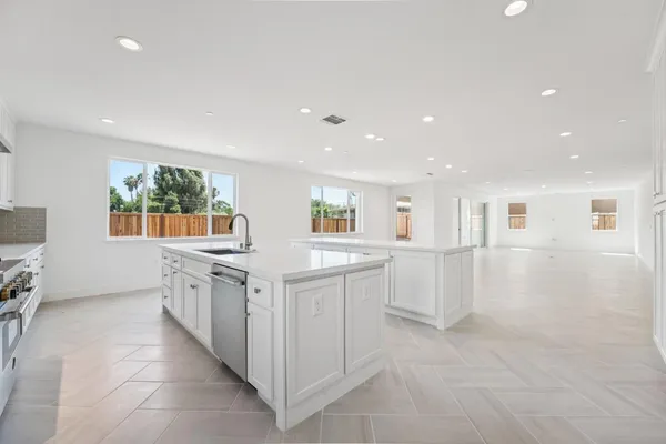 a kitchen with white cabinets and sink