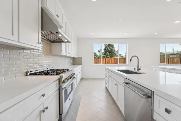 a kitchen with stainless steel appliances granite countertop a sink and a stove top oven