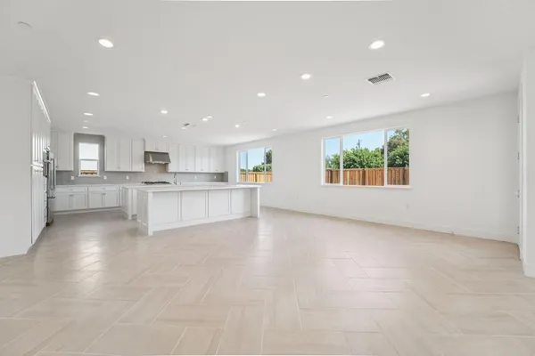 a view of a kitchen with a sink wooden cabinets and a window