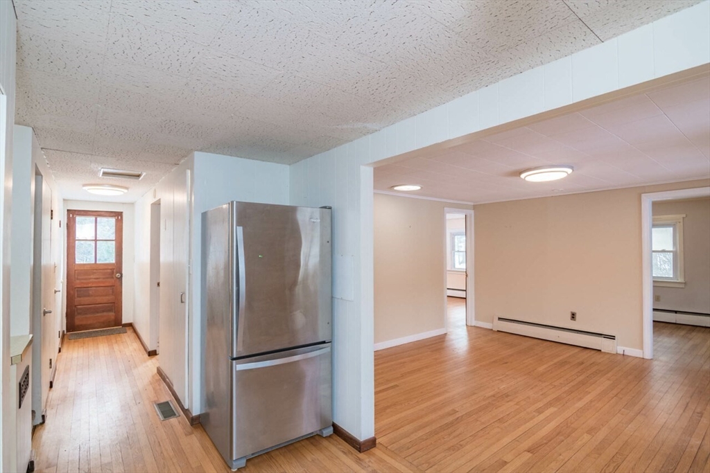 300 Main Road Westhampton, MA 01027 - Photo 6 of 35 a view of an empty room with wooden floor and a kitchen