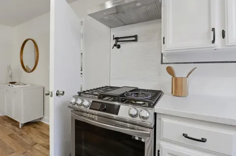 a stove top oven sitting inside of a kitchen